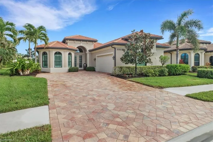 Mediterranean / spanish-style house featuring a front lawn and a garage