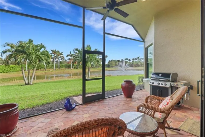 Sunroom with ceiling fan and a water view