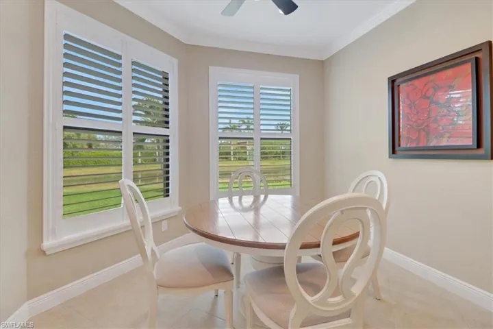 Dining space featuring ceiling fan, light tile patterned floors, and crown molding