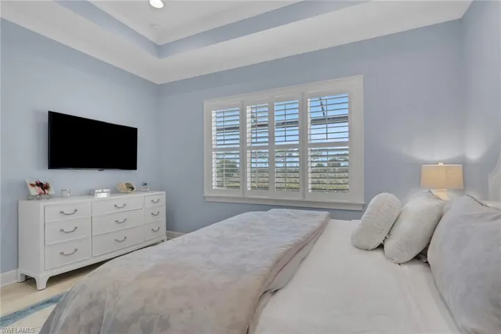 Bedroom featuring a tray ceiling and light wood finished floors