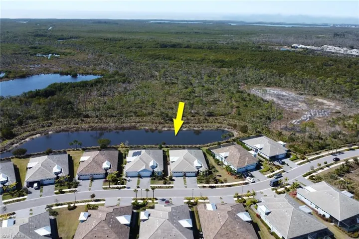 Aerial view of property and surrounding area with a large body of water and nearby suburban area