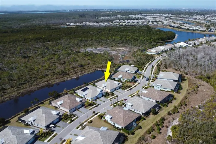 Aerial view of property and surrounding area with nearby suburban area and a large body of water