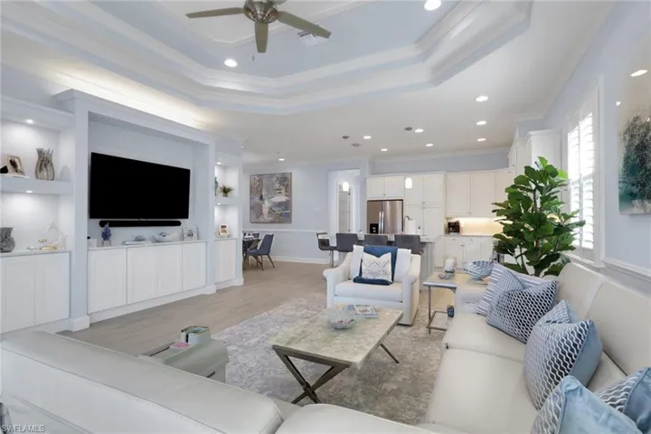 Living area featuring light wood finished floors, built in features, recessed lighting, a ceiling fan, and crown molding