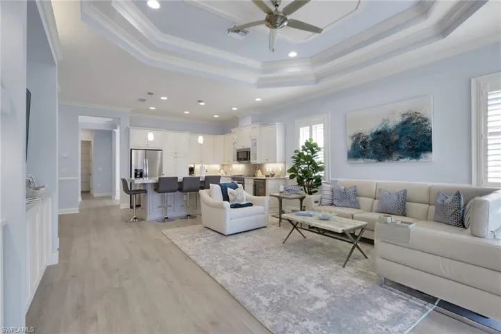Living room featuring ceiling fan, light wood-type flooring, crown molding, and recessed lighting