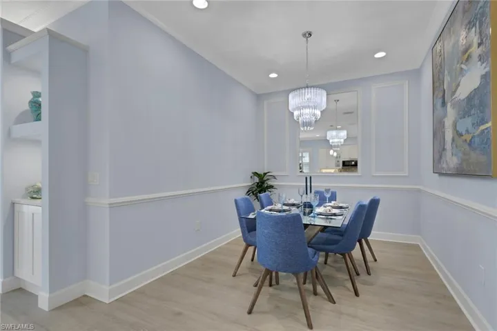 Dining room with light wood-style flooring and a chandelier