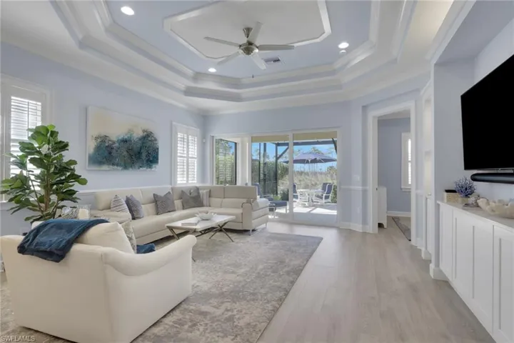 Living area featuring a ceiling fan, light wood-type flooring, healthy amount of natural light, recessed lighting, and crown molding