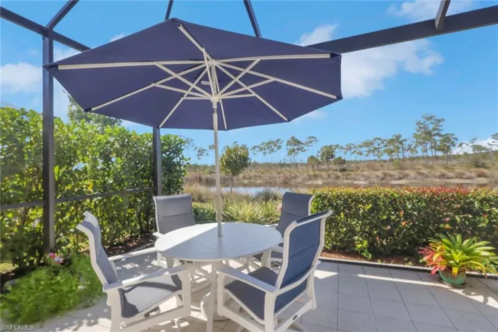 View of patio / terrace with outdoor dining area, a water view, and a lanai