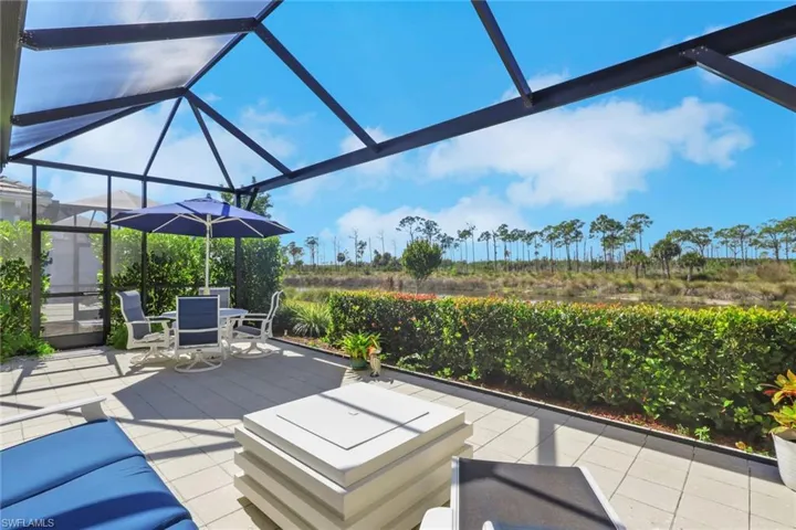 View of patio featuring glass enclosure, outdoor dining area, and a sunroom