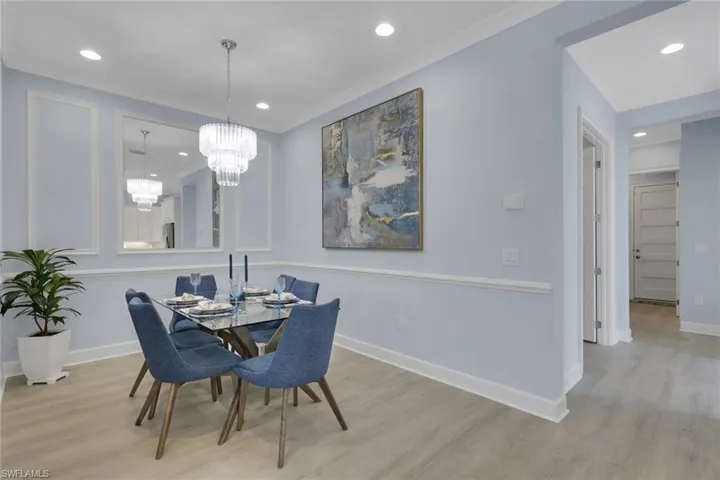 Dining room with light wood finished floors, crown molding, and hanging lights