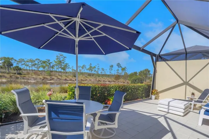 View of patio featuring a lanai, a sunroom, a water view, and outdoor dining space