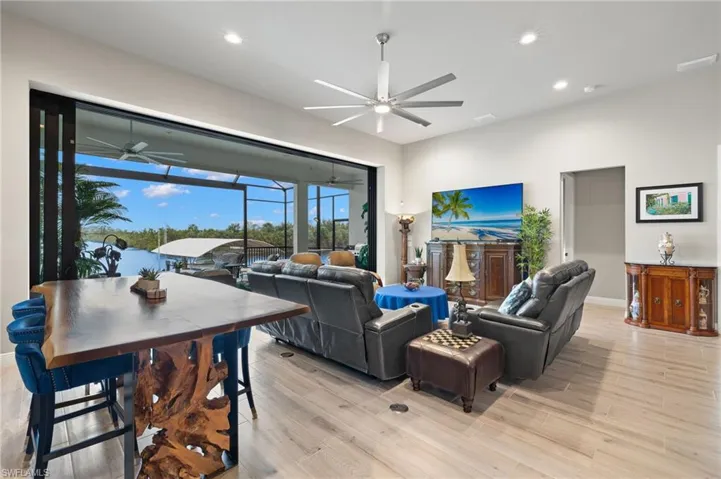 Living room with light wood-style floors, recessed lighting, a sunroom, and a ceiling fan