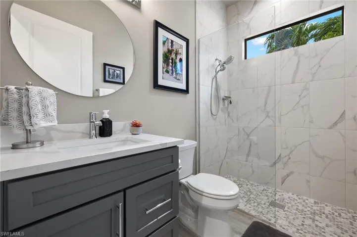 Guest bathroom featuring vanity and a marble finish shower