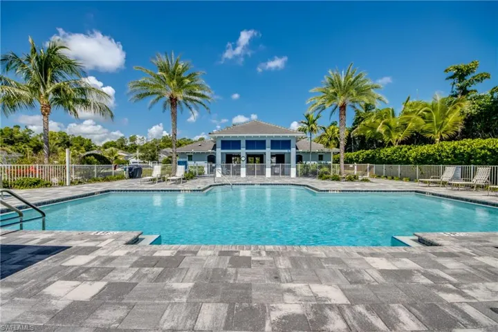 Expansive community swimming pool with integrated steps, surrounded by a paver deck