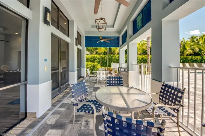 Cover outdoor community seating area featuring paver deck, lighting and ceiling fans