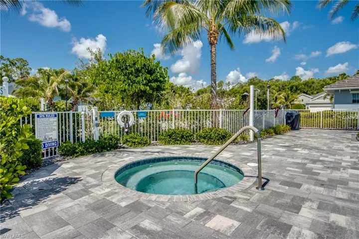 Community circular spa with tiled interior, surrounded by a paver patio