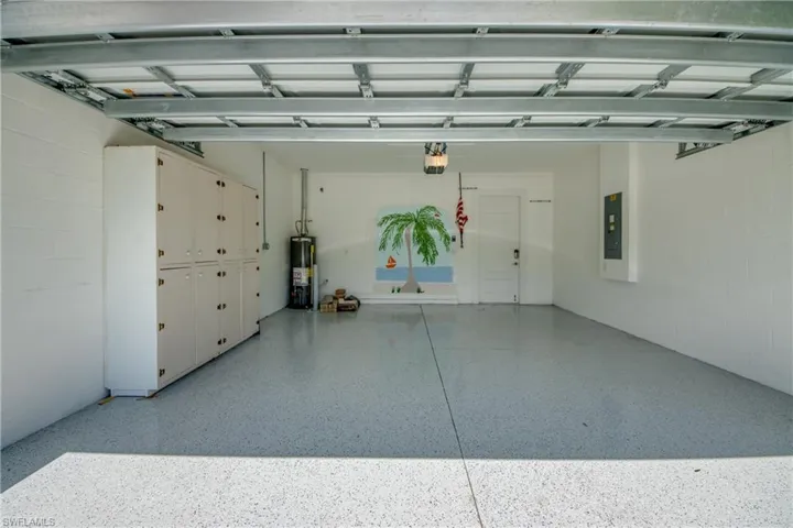 Spacious garage featuring a durable epoxy-coated floor, built-in storage cabinetry
