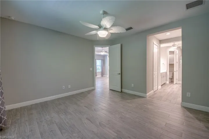 Primary bedroom with wood-finish tile flooring