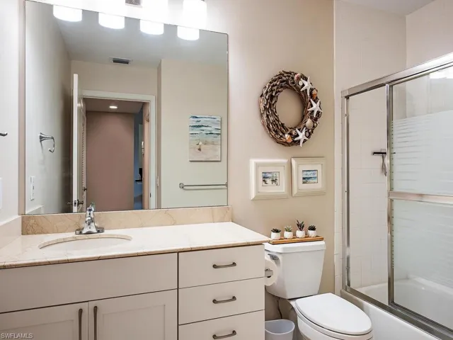 Full bathroom featuring toilet, enclosed tub / shower combo, and vanity