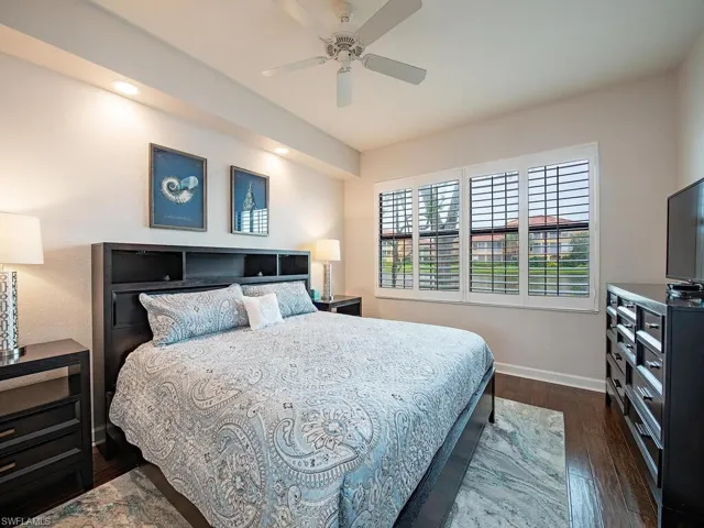 Bedroom with ceiling fan and dark hardwood / wood-style floors