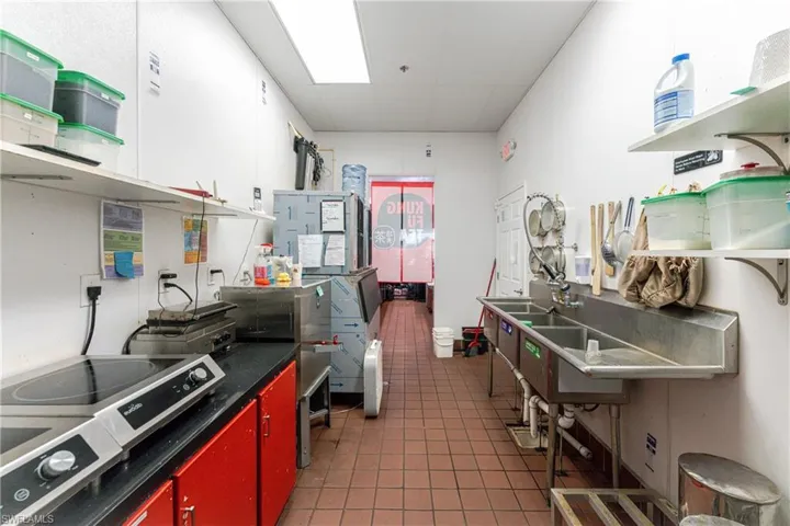 Kitchen with dark tile patterned floors and white cabinetry