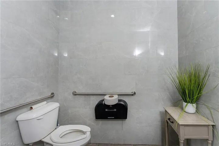 Bathroom with toilet and tile walls