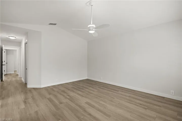 Large Primary Bedroom  featuring vaulted ceiling, light hardwood / wood-style floors, and ceiling fan