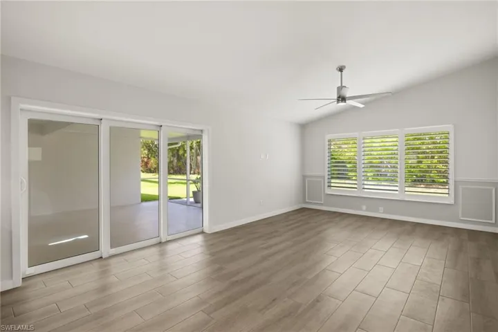 Empty room featuring ceiling fan, vaulted ceiling, and light hardwood / wood-style floors