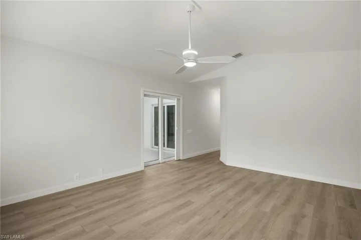 Large Primary Bedroom  featuring vaulted ceiling, light hardwood / wood-style floors, and ceiling fan