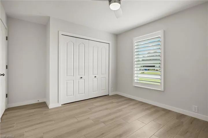 Unfurnished bedroom with light hardwood / wood-style floors, ceiling fan, and a closet
