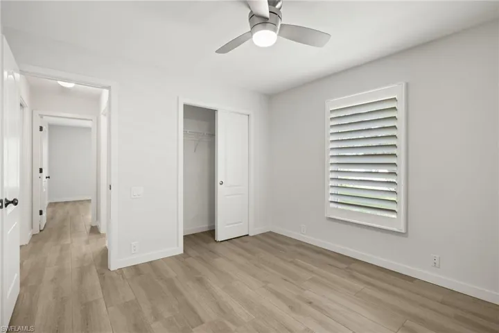 Unfurnished bedroom featuring a closet, light hardwood / wood-style floors, and ceiling fan