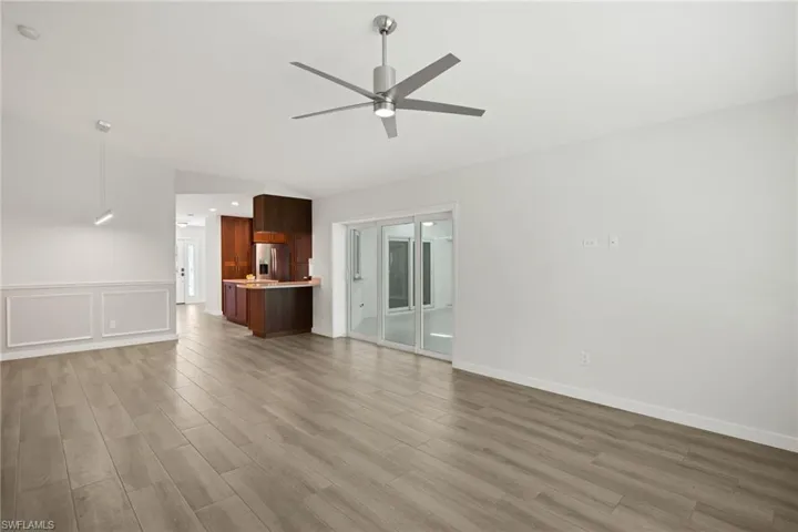Unfurnished living room featuring vaulted ceiling, ceiling fan, and hardwood / wood-style floors