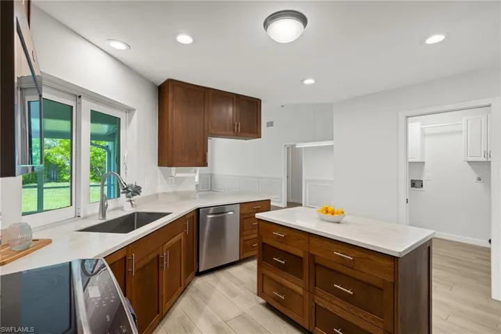 Kitchen with light wood-type flooring, dishwasher, stove, and sink