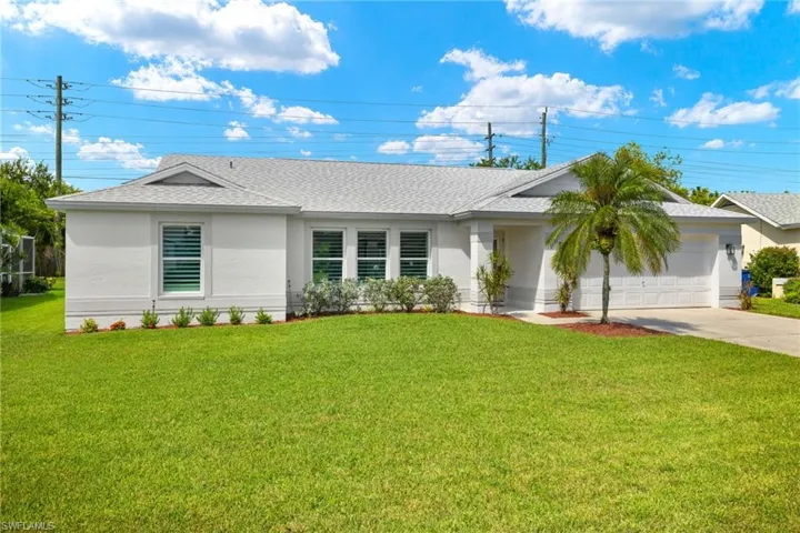 Ranch-style home featuring a front lawn and a garage