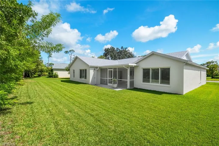 Rear view of property featuring a sunroom and a yard