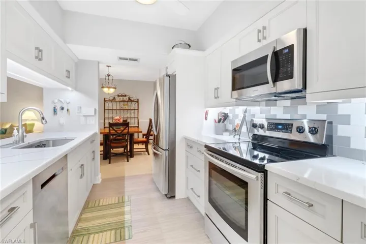 Updated kitchen featuring stainless steel appliances, white cabinetry