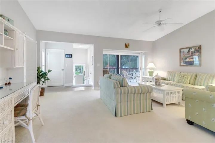 Living room with ceiling fan and lofted ceiling