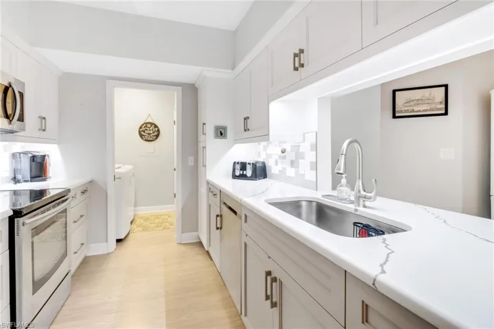 Clean/bright kitchen featuring separate laundry room with washer and clothes dryer