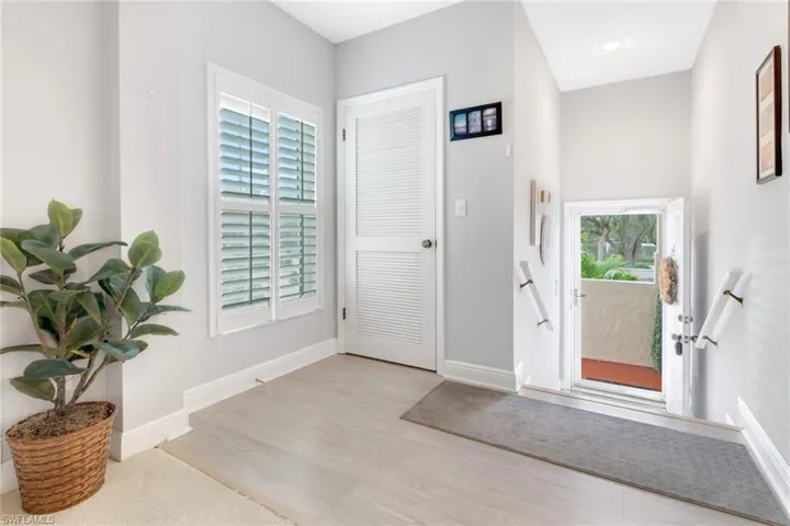 Entryway with a wealth of natural light and light hardwood-style flooring
