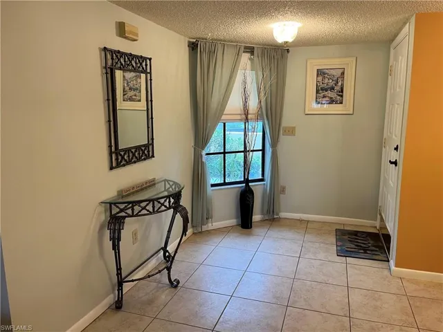 Entryway featuring a textured ceiling and light tile patterned floors