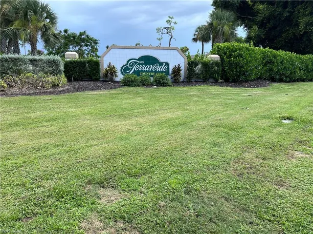 Community / neighborhood sign featuring a lawn