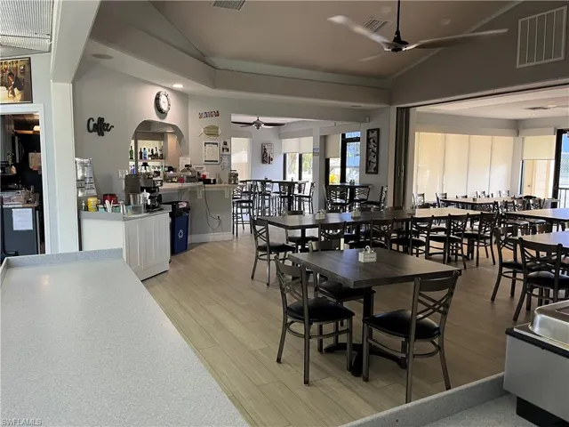 Dining area with a ceiling fan, vaulted ceiling, light wood-style flooring, arched walkways, and recessed lighting