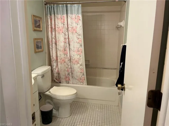 Full bath featuring shower / tub combo with curtain, tile patterned flooring, and vanity