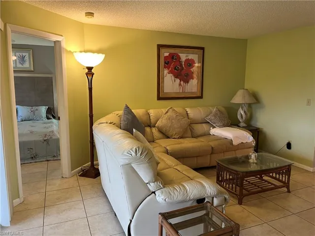 Living area featuring light tile patterned flooring and a textured ceiling