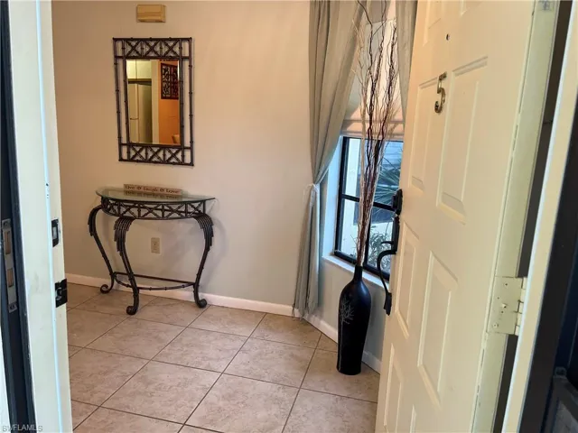 Foyer entrance with baseboards and light tile patterned floors