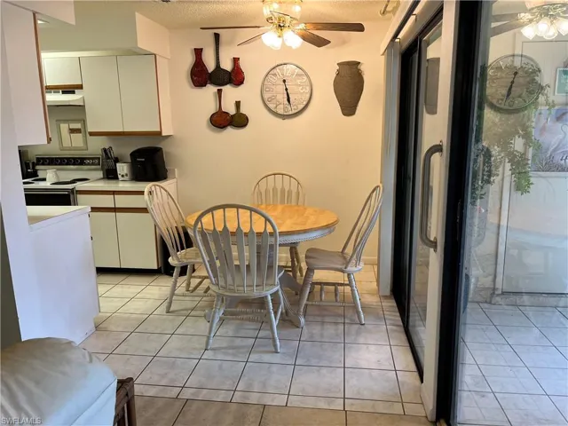 Dining space with a ceiling fan, a textured ceiling, and light tile patterned floors