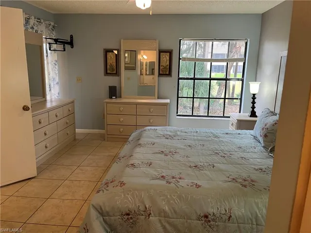 Bedroom featuring light tile patterned floors and a textured ceiling