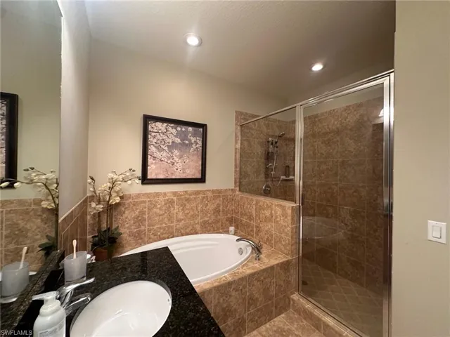 Bathroom featuring a garden tub, vanity, and a stall shower