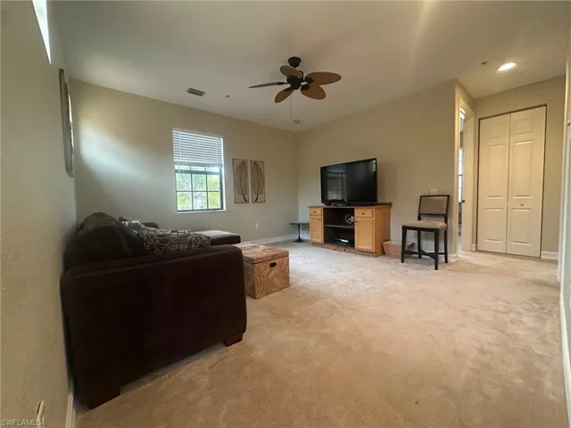Living room with light carpet and ceiling fan