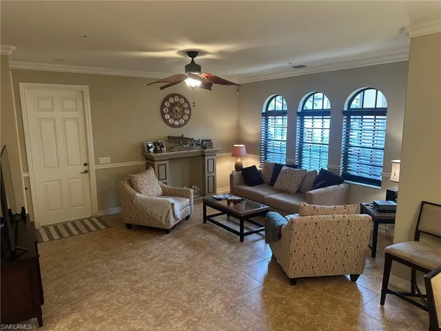 Living room with ornamental molding and ceiling fan