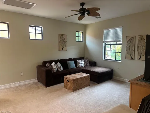 Living room featuring carpet flooring and a ceiling fan